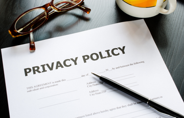 document titled privacy policy on a desk with a pair of glasses and a mug